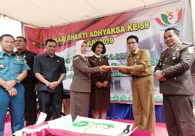 Staff Ahli Pemko Dumai, Bambang Hardiyanto menyerahkan potongan kue kepada salah satu pegawai Kejaksaan Negeri Dumai dalam kegiatan syukuran Hari Bhakti Adhyaksa ke 59, di Kantor Kejari Dumai. 