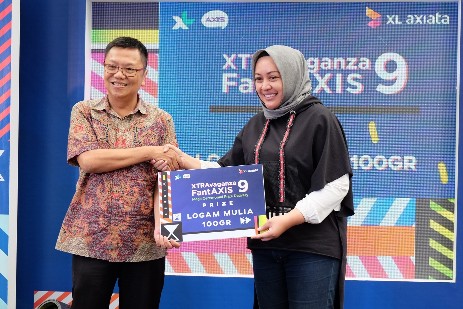 Group Head Corporate Communication XL Axiata, Tri Wahyuningsih (kanan)  bersama dengan pemenang hadiah emas program Xtravaganza FantAxis, Djuherman (kiri) dalam acara penyerahan hadiah program XTRAvaganza & FantAXIS dan XpLay & BombAXIS di Jakarta, Senin (15/7/2019).   