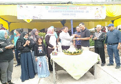 Sekda Abdul Haris, berikan nasi tumpeng ke Camat Rambah Samo Adi Irawan saat rayakan hari jadi Kecamatan Rabah samo ke 24 yang berlangsung meriah.