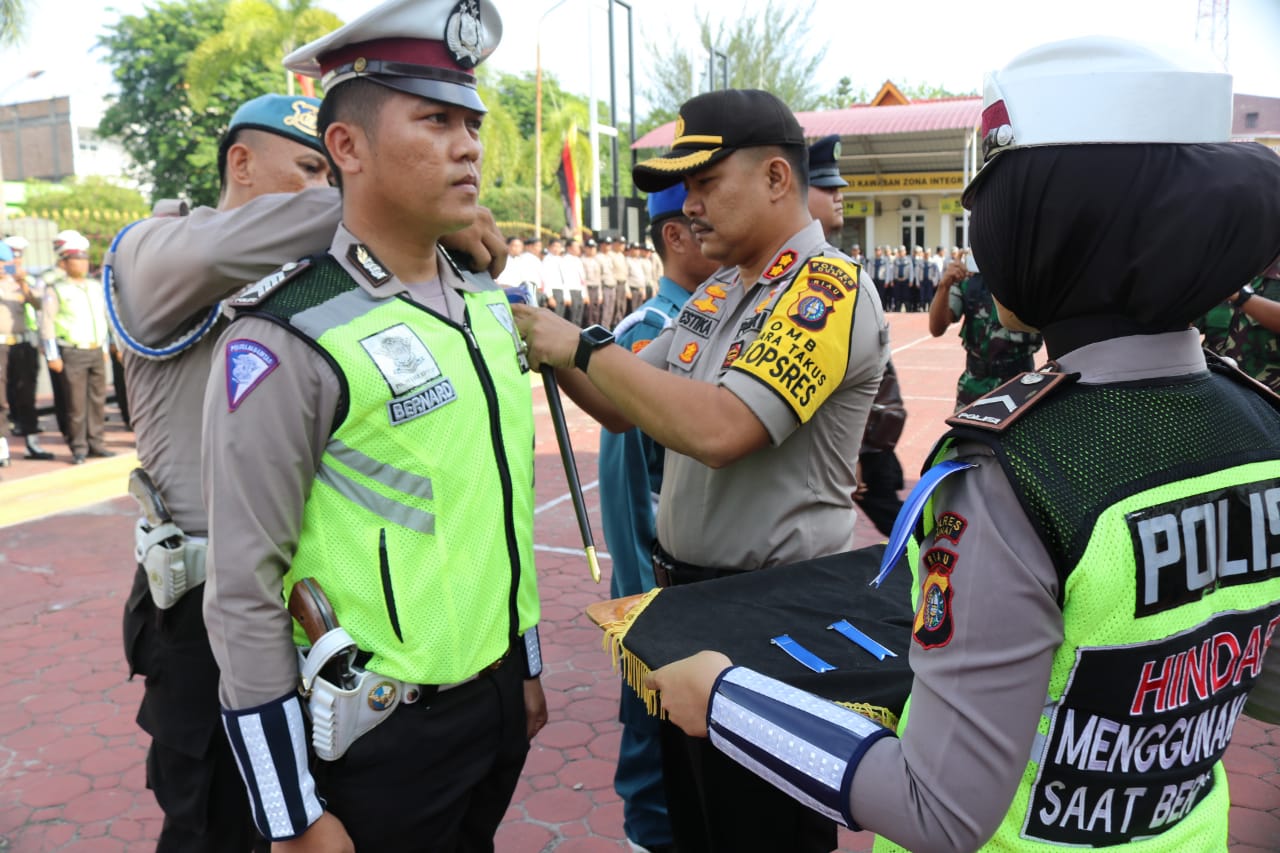 Kapolres Dumai AKBP Restika P Nainggolan SIK mengenakan pita tanda operasi l Keselamatan Muara Takus 2019