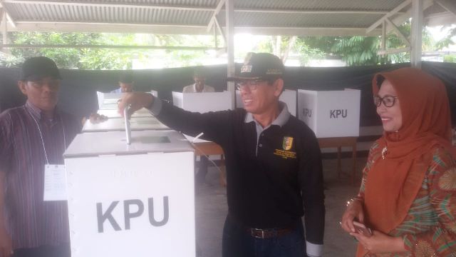 Bupati Kuansing H Mursini didampingi istri mencoblos di TPS 03 Lingkungan Jao, Kelurahan Simpang Tiga.