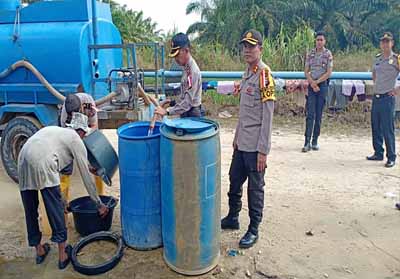 Kapolres Rokan Hilir AKBP Sigit Adiwuryanto SIK MH bersama Kapolsek Tanah Putih Kompol L Simatupang SH salurkan bantuan air bersih untuk warga.