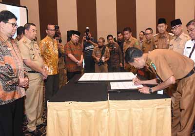 Kadis Kominfotik Bengkalis, Johansyah Syafri ketika menandatangani Komitmen Bersama di hadapan Wakil Gubernur Riau dan Ombudsman RI, Selasa, 21 Mei 2019.