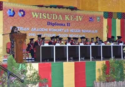   Asisten Pemerintahan Hj Umi Kalsum saat membacakan sambutan Bupati Bengkalis pada Wisuda Ahli Muda ke-4 Rintisan Akademi Komunitas Negeri Bengkalis PDD Politeknik Negeri Bengkalis.