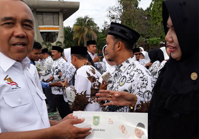   Gubernur Riau, Arsyadjuliandi Rahman, memberi penghargaan  Sekolah Peduli dan Berbudaya pada Kepala Sekolah SMAN 1 Ukui, Nova Damayanti S.Pd, M.Pd, di halaman Kantor Gubernur Riau.