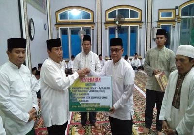 Bupati Sukiman, serahkan bantuan kepada pengurus masjid saat Safari Ramadan tingkat Kabupaten Rohul, di Desa Rawa Makmur Kecamatan Bonai Darussalam.