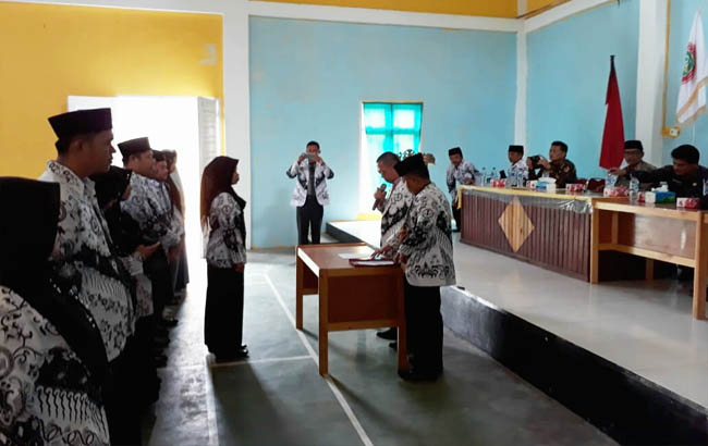   Ketua PGRI Pelalawan Anton Timur didampingi Sekretaris PGRI Pelalawan Marzuki saat melantik jajaran Pengurus Cabang PGRI Bunut di aula Kantor Camat Bunut, Kamis (6/9/2018).