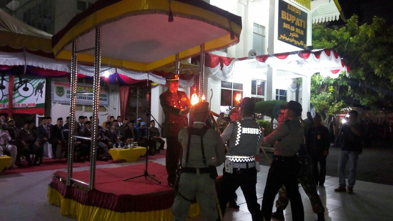 Dandim 0321 Rohil, Letkol Arh Bambang Sukisworo menyalakan api obor utama kepada perwakilan TNI/ Polri, Dishubkominfo dan Satpol PP- Linmas Rohil.