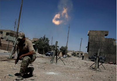  Anggota pasukan reaksi cepat Irak menembakkan mortar kepada posisi militan ISIS di barat Mosul, Irak. FOTO: REUTERS/Alkis Konstantinidis