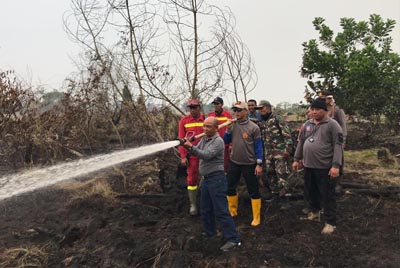  Bupati Harris didampingi Kapolres Pelalawan AKBP Kaswandi saat melakukan pemadaman api di Kecamatan Langgam, Kabupaten Pelalawan, belum lama ini.