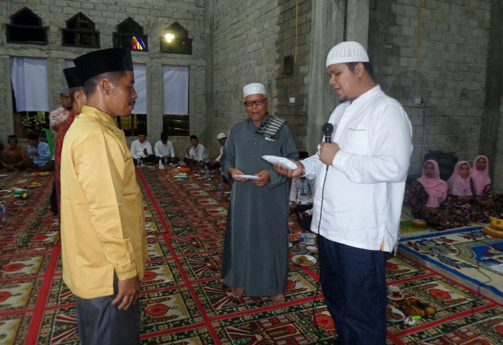 Ketua DPRD Kuansing Andi Putra serahkan sumbangan DPRD Kuansing kepada kades dan pengurus masjid saat safari ramadhan di Desa Tanjung Medang.
