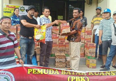 Ketua Pemuda Batak Kuansing (PBK) Bripka Hardianto Manik serahkan bantuan bagi korban banjir di Desa Petapahan Gunung Toar