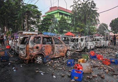   Cars that were burned by protesters are seen during an overnight demonstration near by the Elections Oversight Body (Bawaslu) in Jakarta. PHOTOGRAPH: Bay Ismoyo/AFP/Getty Images