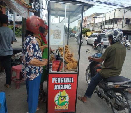 Susi, pemilik usaha gorengan Jasaki Pergedel Jagung sedang melayani pembeli (foto/riki)