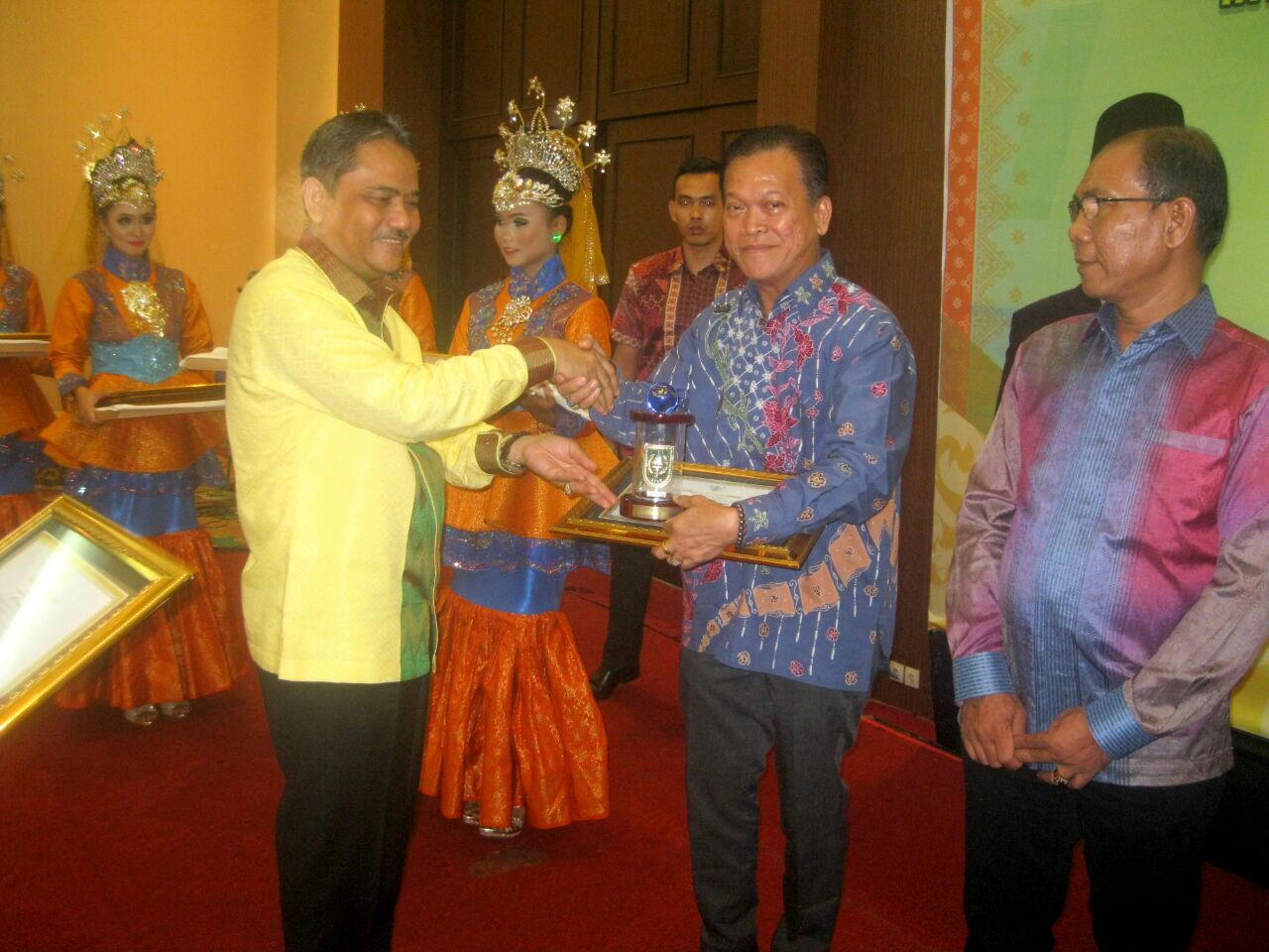 Sekdaprov Riau, Ahmad Hijazi serahkan sertifikat dan piala penghargaan kepada Head CSR & Sustainability Asian Agri, Welly Pardede pada acara Riau Investment Award 2016 di Pekanbaru