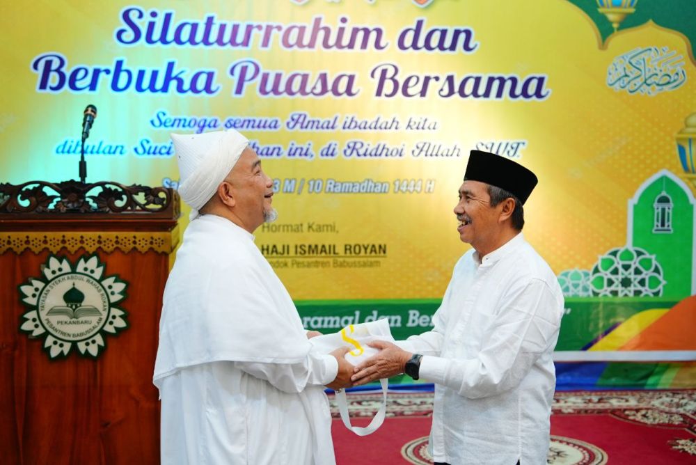 Gubernur Riau, Syamsuar menyerahkan bantuan CSR BRK Syariah kepada Pimpinan Ponpes Babussalam Pekanbaru, Tuan Guru Syekh Haji Ismail Royan.(foto: mcr)