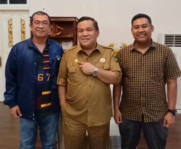 Ketua PWI Riau, Raja Isyam Azwar memberikan pin emas ke Pj Gubri, SF Hariyanto (foto/ist)