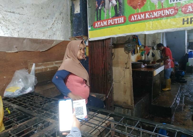 Seorang pembeli membayar pakai QRIS di Pasar Kodim Pekanbaru (foto/riki)