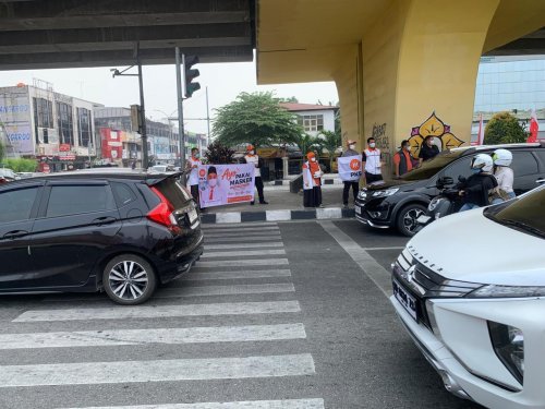 Anggota DPRD Kota Pekanbaru, dr Meiza Ningsih bagi-bagi masker untuk pengendara di jalan (foto/Mimi)