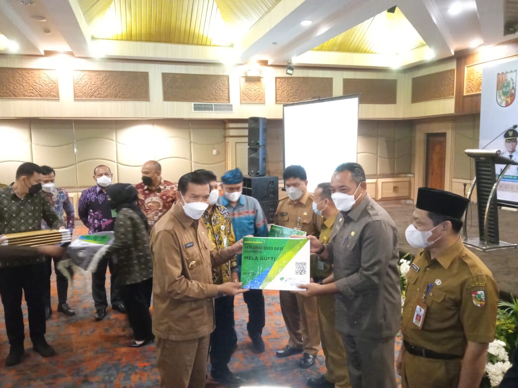 Penyerahan jaminan sosial secara simbolis oleh Walikota Pekanbaru Firdaus kepada Ingot Ahmad Hutasuhut mewakili pekerja.