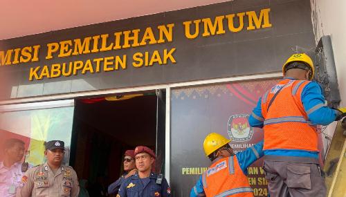 Petugas PLN memperbaiki meteran listrik KPU Siak yang terbakar saat momen Paslon Afni-Syamsurizal mendaftar untuk Pilkada Siak 2024.(foto: diana/halloriau.com)