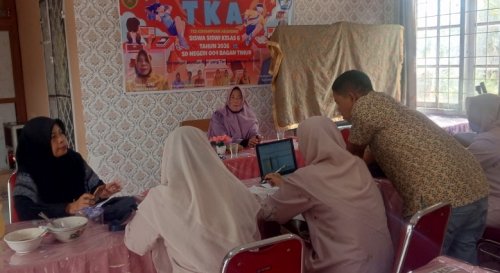 Kepsek SDN 004 Bagan Timur, Jumiar bersama para guru lainnya menerima berkas pendaftaran ulang bagi calon siswa baru (foto/afrizal)