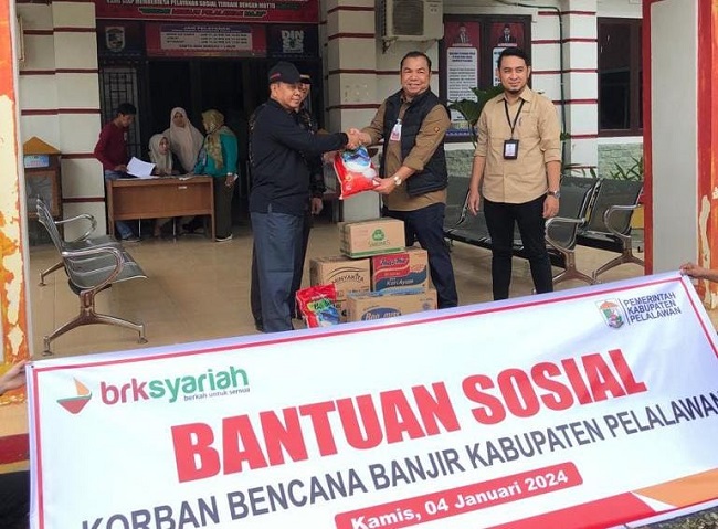 Branch Manager BRK Syariah Cabang Pangkalan Kerinci, Bobby Ferdian kepada Dinas Sosial Kabupaten Pelalawan serahkan Paket sembako berisikan beras, minyak goreng, sarden, teh celup, indomie dan susu kental manis, Kamis (4/1/2024) di Kantor Dinas Sosial Kabupaten Pelalawan.