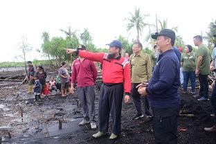 Asisten Sekda Bengkalis, Andris Wasono menunjuk daratan yang sudah jadi laut karena abrasi (foto/Zul)