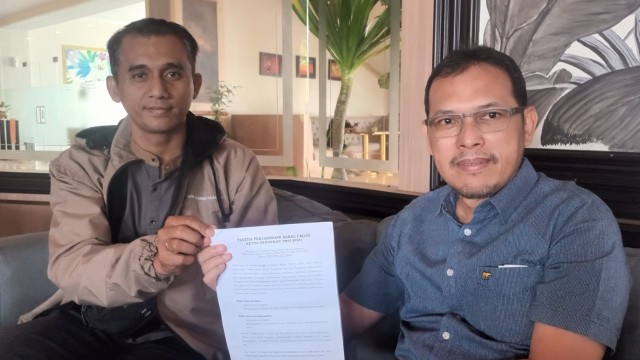 Ketua Tim Pemenangan Edi Basri, Adi Nugroho bersama Zelfriandi, memperlihatkan surat pemberitahuan dari panitia penjaringan calon Ketum PBSI Riau (foto/riaupos)