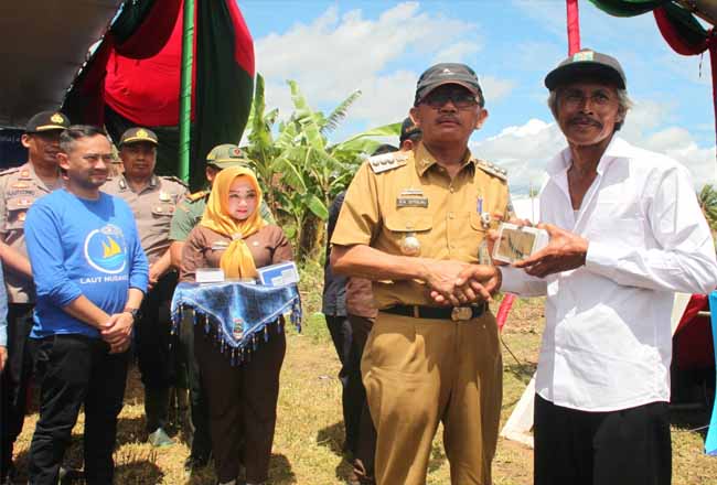 Bupati Pesisir Barat, Dr. Drs. Agus Istiqlal, SH, MH (kedua dari kanan) menyerahkan paket aplikasi Laut Nusantara kepada warga nelayan di sela-sela peresmian jaringan 4G Universal Service Obligation (USO) milik XL Axiata di Desa Desa Bandar Dalam, Kecamatan Bengkunat Belimbing, Kabupaten Pesisir Barat, Lampung, Selasa (14/1).  