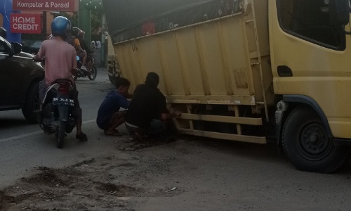 Mobil truk terpuruk dibekas galian SPAM PDAM, Jalan Durian Pekanbaru yang tak ditimbun dengan baik.(foto:rivo/halloriau.com)