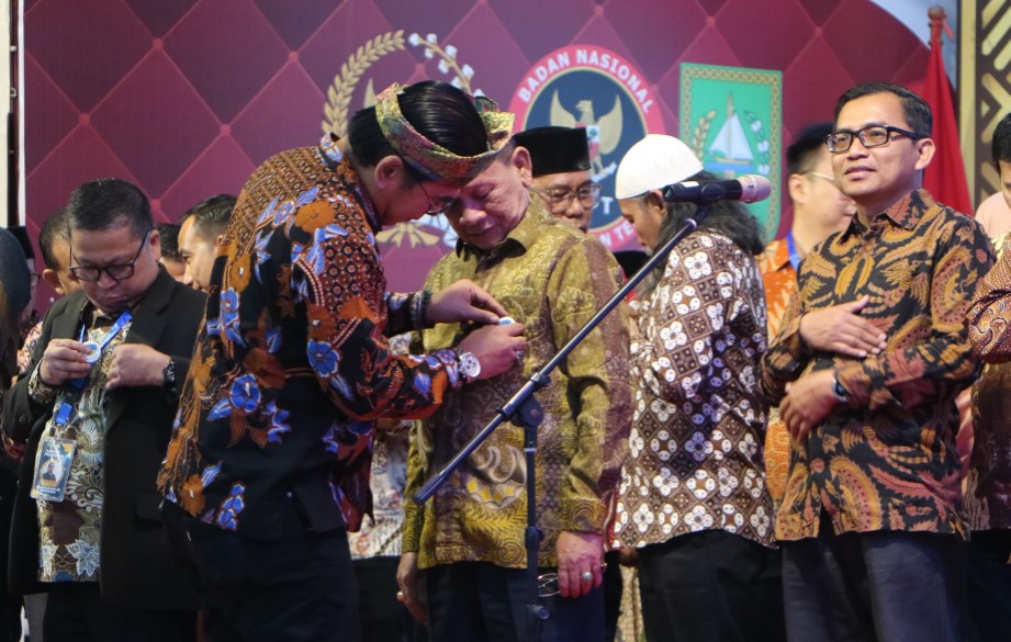Ketum ADI Prof Mohammed Ali Berawi menyematkan pin ke Ketua ADI Riau, Prof Jimmi (foto/ist)