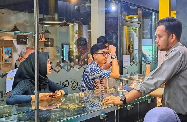 Putri Ayu mengantre membeli emas di Galeri 24 Pegadaian, Jalan Sudirman, Pekanbaru (foto/riki)