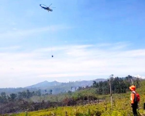 Helikopter melakukan water bombing padamkan api yang membakar kawasan Hutan Bukit Suligi.
