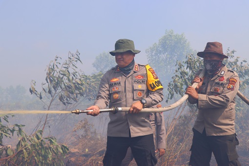 Kapolres Rohil, AKBP Isa Imam Syahroni turun langsung dalam upaya pemadaman di Tanah Putih  (foto/afrizal)