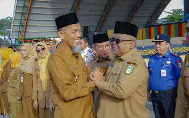 Walikota Dumai, Paisal menyalami Kadiskominfotiksan Dumai, Khairil Adli usai memimpin Apel gabungan (foto/bambang)