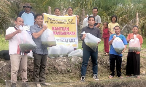 PT Madukoro Lestari memberikan bantuan bibit ikan patin dan pakan kepada kelompok budidaya ikan di Desa Sungai Ara Pelalawan.(foto: andi/halloriau.com)