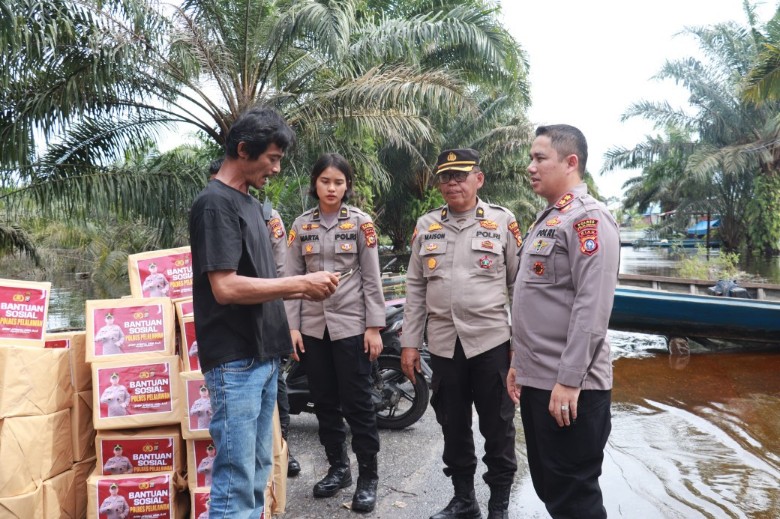 Kapolres Pelalawan, AKBP Afrizal salurkan bantuan sembako ke warga terdampak banjir Dusun Kualo (foto/Andy)