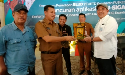 Ketua PWI Riau Zulmansyah Sekedang menerima plakat dari Plt Bupati Kuansing Suhardiman Amby.(foto: istimewa)