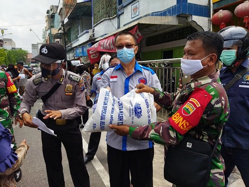 Ketua YM2TI Rendi Gunawan alias Kho Peng membagikan sembako berupa beras kapada masyarakat. 