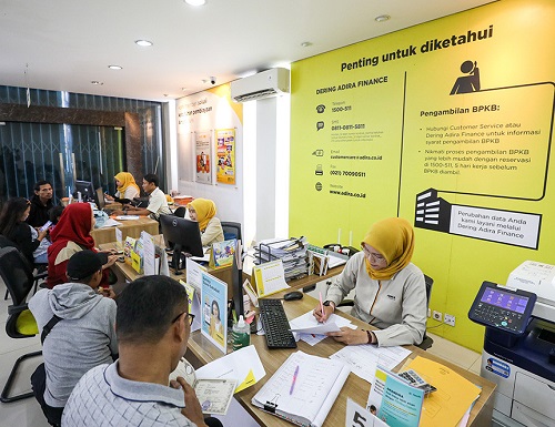 Karyawan melayani nasabah di kantor cabang Adira Finance di Jakarta, Senin (4/3).