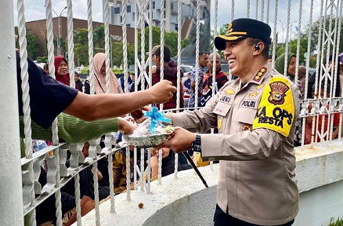 Kapolresta Pekanbaru membagikan buah kepada pendemo di depan Kantor Gubernur Riau.(foto: istimewa)