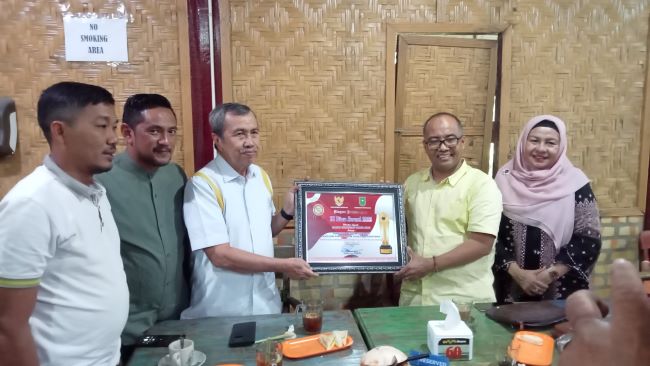 Syamsuar dan jajaran Golkar Riau tunjukkan plakat penghargaan KI Award (foto:rinai/halloriau)