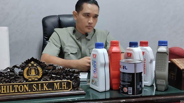 Kasat Reskrim Polres Kuansing, AKP Shilton menunjukkan sampel oli palsu yang diamankan dari 3 tersangka.(foto: tribunpekanbaru.com)