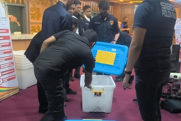 Penyidik Polda Riau saat menyita sejumlah dokumen dari penggeledahan Kantor DPRD Riau.(foto: kompas.com)