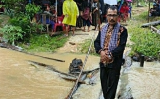 Anggota DPRD Inhu Martimbang Simbolon di lokasi jembatan yang rusak akibat luapan anak sungai.