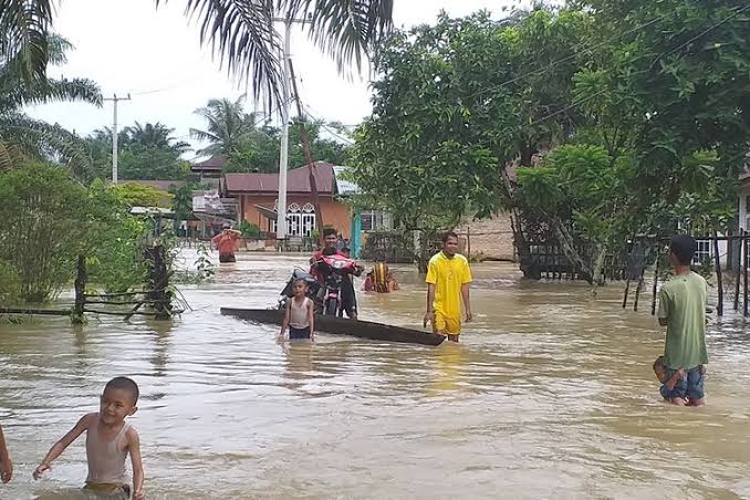Warga Kampar beraktivitas di tengah bencana banjir.