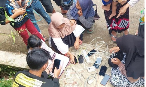 Warga sedang mengisi baterai ponsel mereka dari genset yang disediakan tim teknisi XL Axiata di Desa Cijedil, Kecamatan Cugenang, Cianjur, Selasa (22/11).(foto: istimewa)