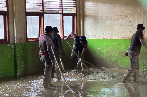 Personel Satpol PP Riau bersihkan sisa lumpur di dalam ruang kelas pasca banjir bandang di Aceh Tamiang.(foto: mcr)