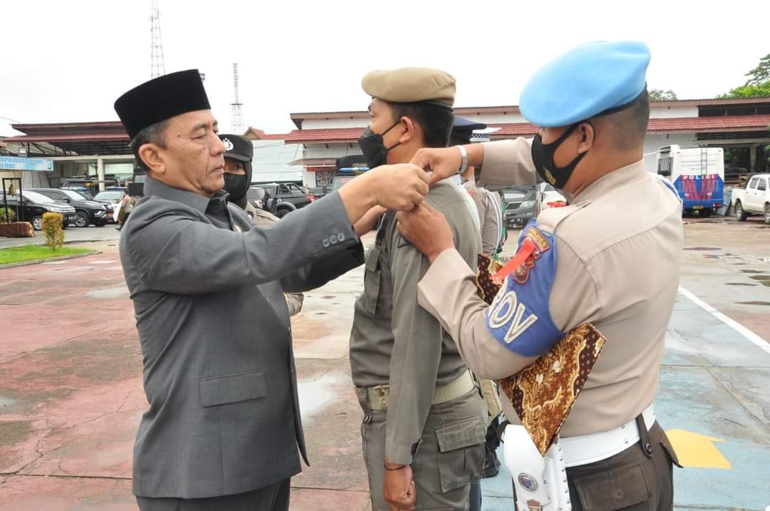 Wakil Bupati Inhu, Junaidi Rachmat memasangkan pita tanda dimulainya Ops Lilin Lancang Kuning 2022.(foto: andri/halloriau.com)